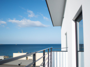 Acquistare un terreno edificabile in Spagna Una moderna casa vacanze bianca con balcone in vetro che si affaccia su un tranquillo mare blu sotto un cielo limpido punteggiato di nuvole: un luogo ideale per investire nella pace e nella bellezza della costa. 0121Management: l'agenzia immobiliare per campeggi e case vacanze.